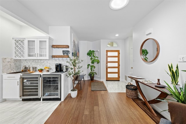 foyer featuring indoor bar, light hardwood / wood-style floors, and beverage cooler