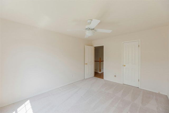 carpeted spare room with ceiling fan