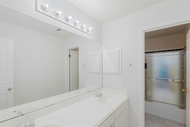 bathroom with enclosed tub / shower combo, vanity, and tile patterned flooring