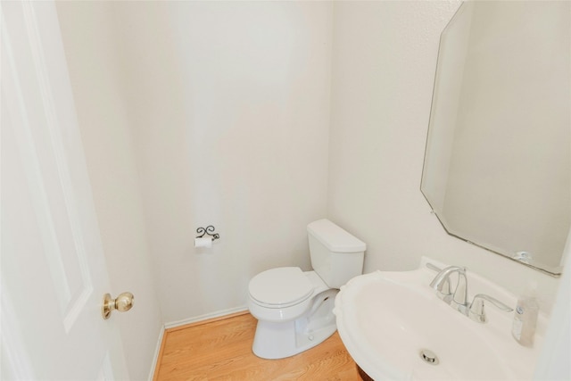 bathroom featuring hardwood / wood-style flooring, sink, and toilet