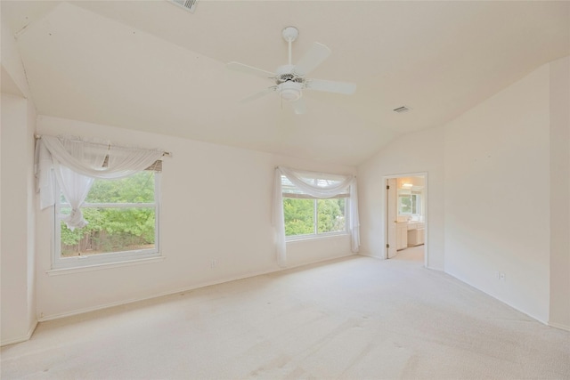 spare room with light carpet, vaulted ceiling, and ceiling fan