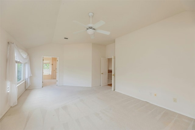 carpeted empty room featuring vaulted ceiling and ceiling fan