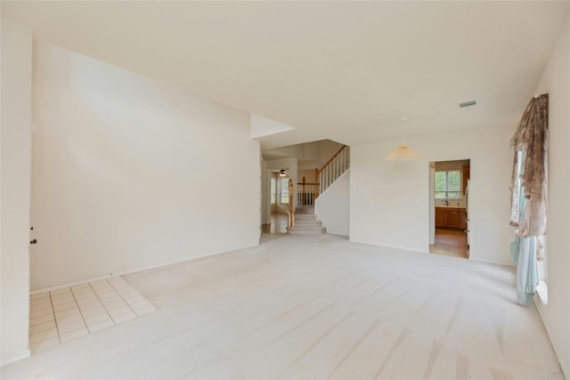 unfurnished living room featuring light carpet