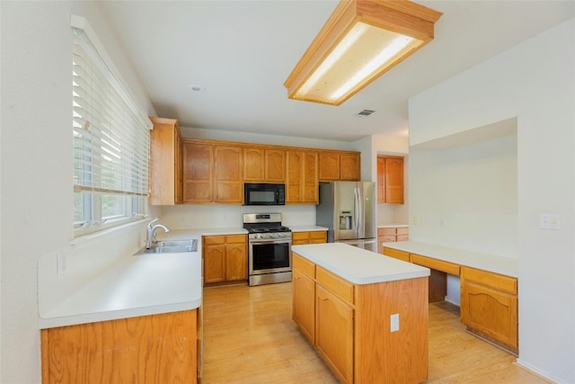 kitchen with stainless steel appliances, a center island, light wood-type flooring, and sink