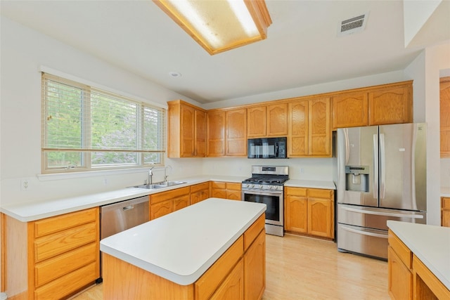 kitchen with light hardwood / wood-style flooring, a center island, appliances with stainless steel finishes, and sink