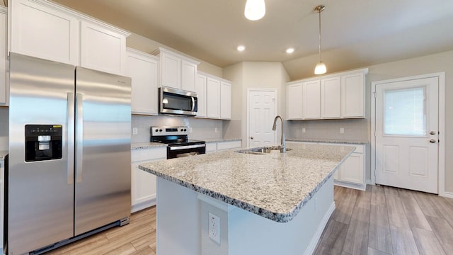 kitchen with light hardwood / wood-style floors, white cabinets, stainless steel appliances, and tasteful backsplash