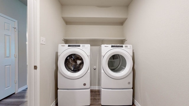 clothes washing area featuring separate washer and dryer and dark wood-type flooring