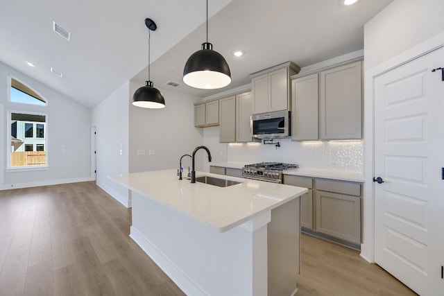 kitchen featuring stainless steel appliances, hanging light fixtures, sink, and gray cabinets