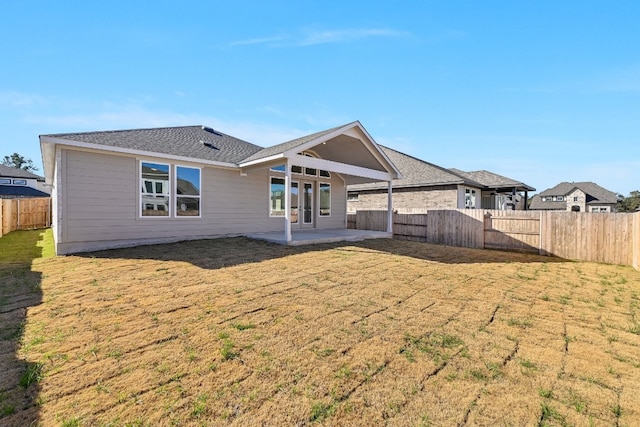 rear view of house featuring a yard and a patio area