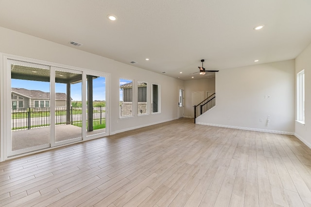 8508 Dongan Dr, Austin, TX 78744 - unfurnished living room with ceiling fan, stairs, light wood-style flooring, and recessed lighting