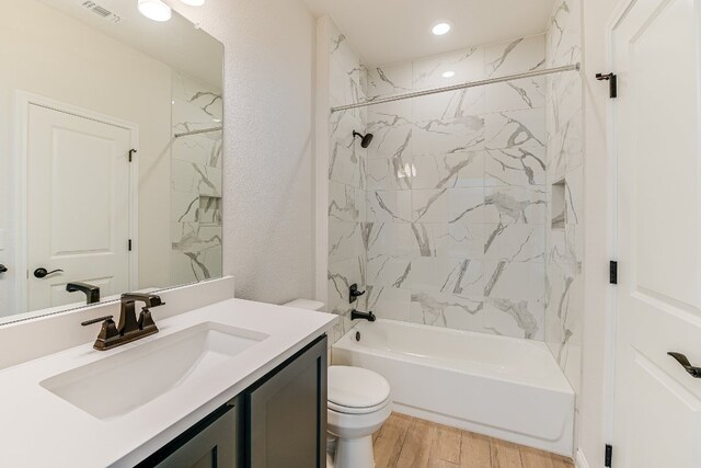 8508 Dongan Dr, Austin, TX 78744 - bathroom featuring vanity, wood finished floors, shower / tub combination, and recessed lighting