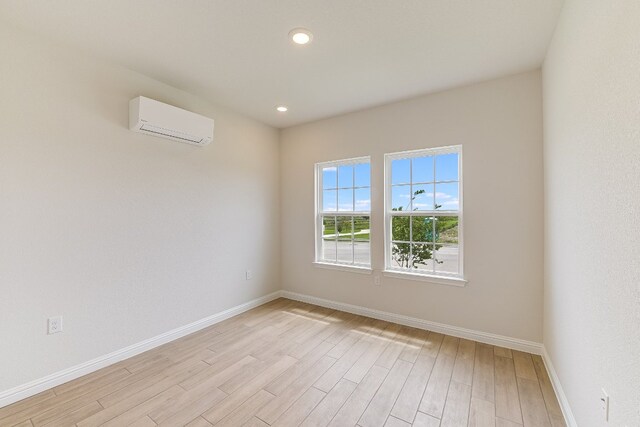 8508 Dongan Dr, Austin, TX 78744 - empty room with a wall unit AC, light wood-style floors, and recessed lighting