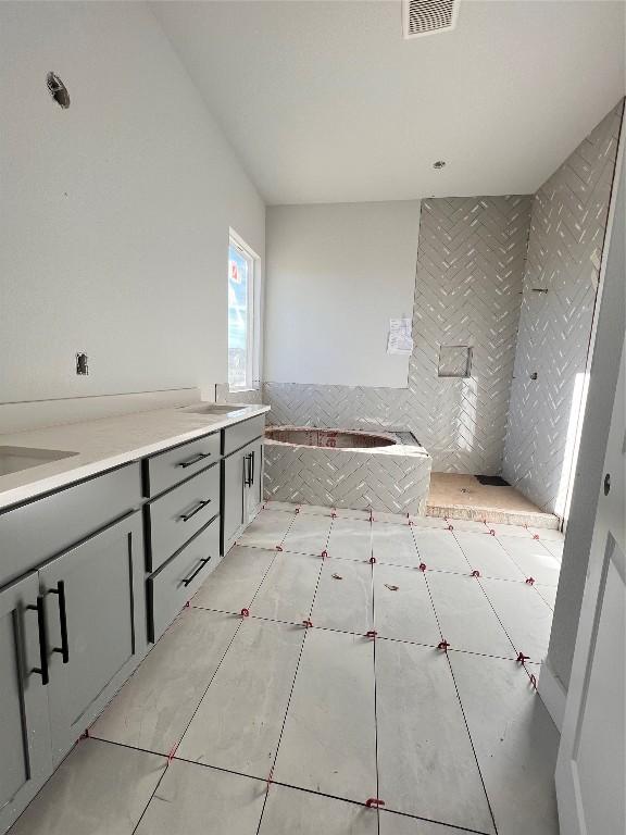 bathroom with tile patterned flooring, a bath, and vanity