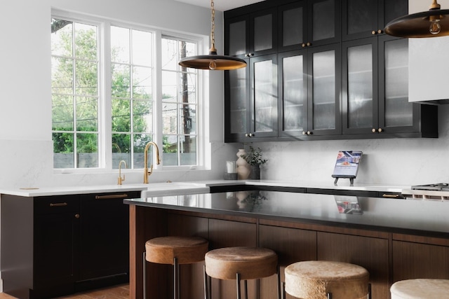 kitchen featuring plenty of natural light, tasteful backsplash, and a breakfast bar area