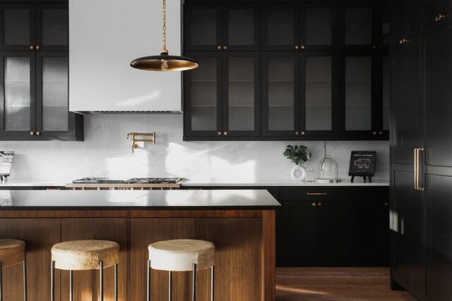 kitchen with pendant lighting, a breakfast bar area, backsplash, and dark hardwood / wood-style flooring