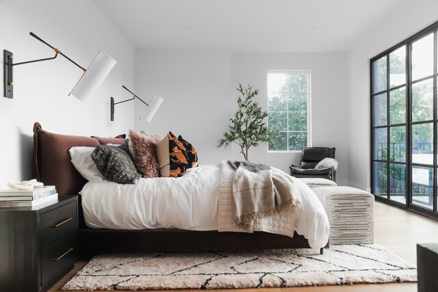 bedroom with light wood-type flooring and access to exterior