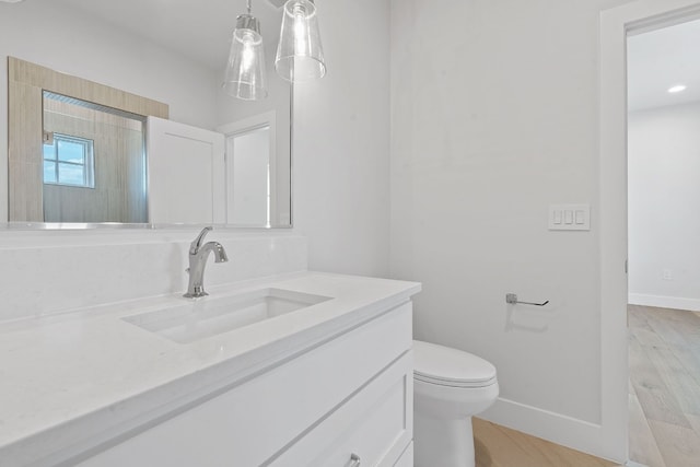 bathroom featuring hardwood / wood-style floors, walk in shower, vanity, and toilet