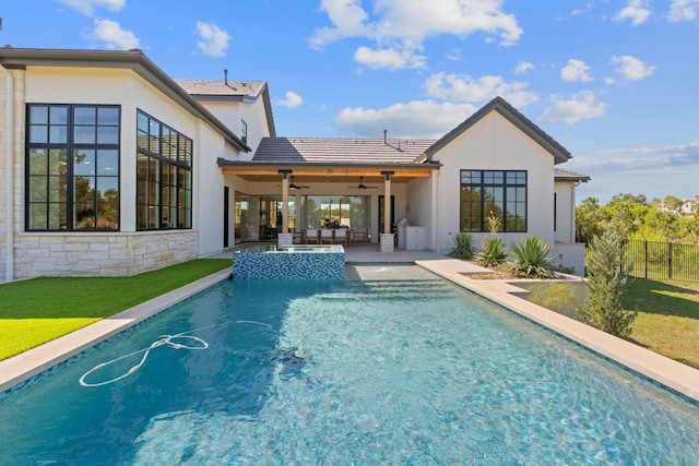 back of property featuring a patio, a yard, ceiling fan, and a fenced in pool