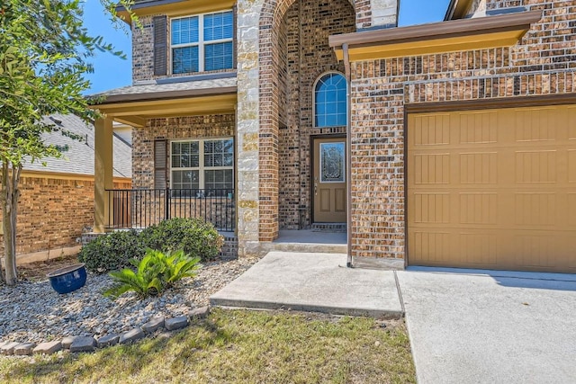 property entrance with an attached garage, a porch, and brick siding