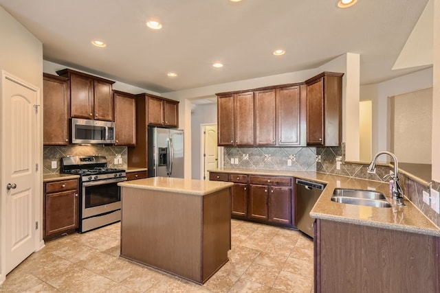 kitchen with light stone countertops, sink, a center island, stainless steel appliances, and backsplash