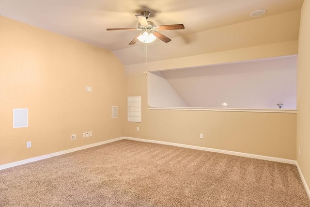 carpeted spare room with lofted ceiling, ceiling fan, and baseboards