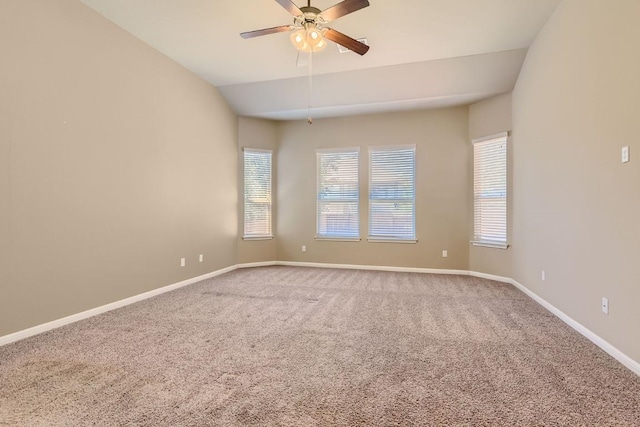 carpeted empty room featuring ceiling fan, baseboards, and vaulted ceiling