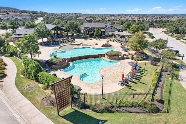 community pool with a residential view, fence, and a patio