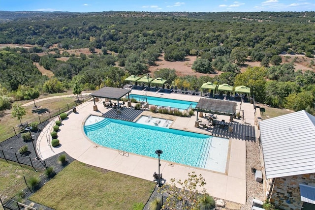 pool featuring a forest view, a patio area, fence, and a gazebo