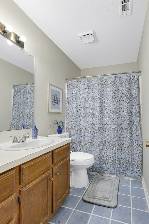 bathroom featuring curtained shower, vanity, toilet, and tile patterned floors