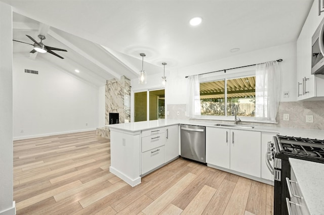 kitchen featuring vaulted ceiling with beams, white cabinets, sink, stainless steel appliances, and light hardwood / wood-style floors