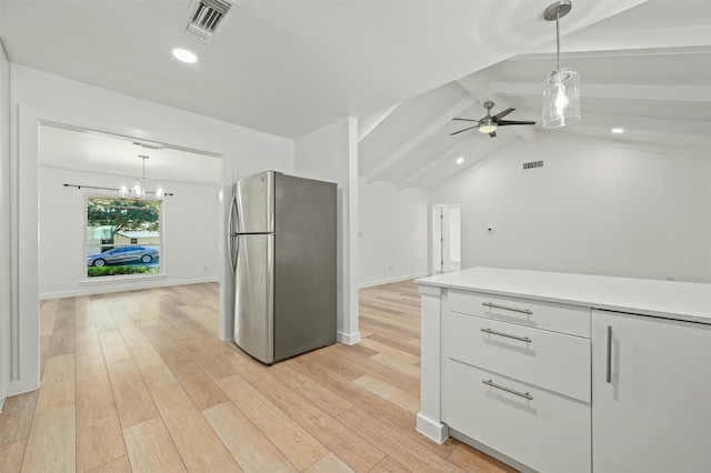 kitchen featuring vaulted ceiling with beams, white cabinetry, decorative light fixtures, and stainless steel fridge