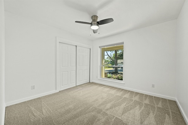 unfurnished bedroom featuring carpet floors, ceiling fan, and a closet