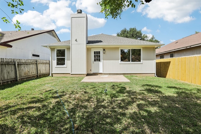 back of house with a yard and a patio