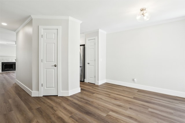 interior space with ornamental molding, a premium fireplace, and dark hardwood / wood-style floors