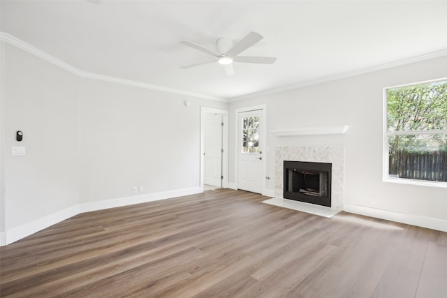 unfurnished living room featuring wood-type flooring, crown molding, and a premium fireplace