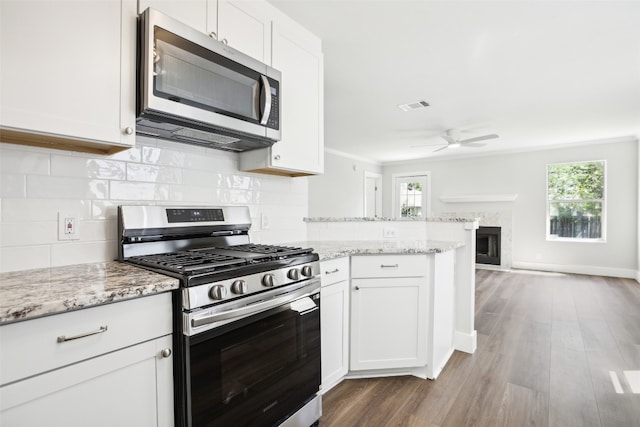 kitchen featuring a wealth of natural light, stainless steel appliances, and white cabinets