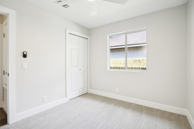 unfurnished bedroom featuring carpet, ceiling fan, and a closet