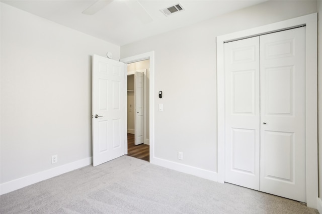 unfurnished bedroom with ceiling fan, a closet, and carpet