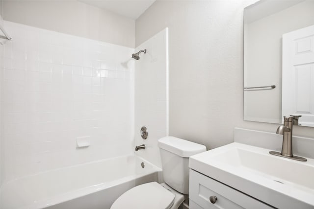 full bathroom featuring tiled shower / bath, vanity, and toilet