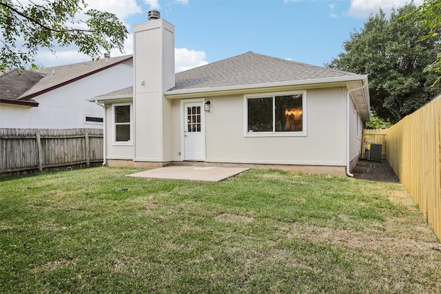 back of property with a lawn, central AC unit, and a patio area