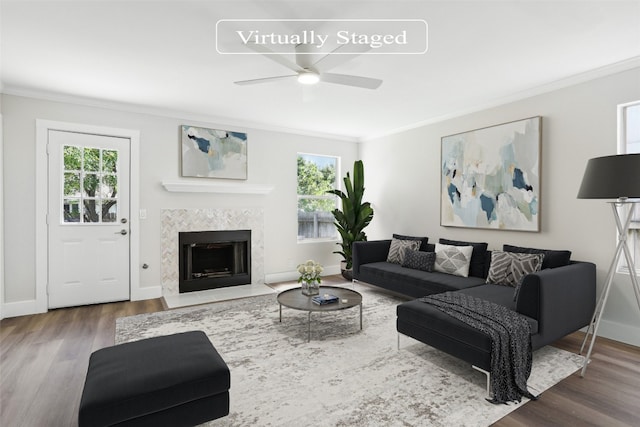 living room with ceiling fan, hardwood / wood-style flooring, a fireplace, and crown molding