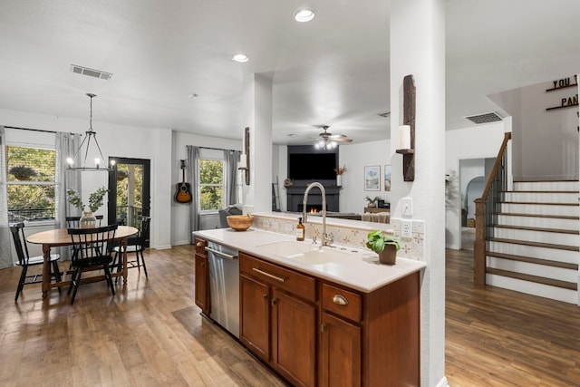 7709 Little Deer Trl, Georgetown, TX 78628 - kitchen with stainless steel dishwasher, visible vents, light countertops, open floor plan, and wood finished floors
