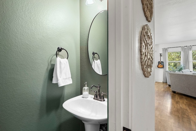 7709 Little Deer Trl, Georgetown, TX 78628 - bathroom with wood finished floors, a textured wall, and a sink