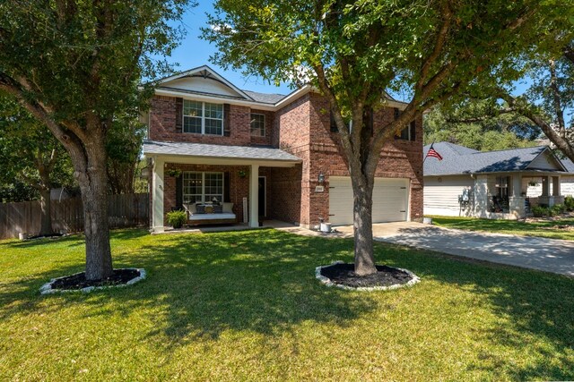 view of front of house with a porch, a garage, and a front lawn