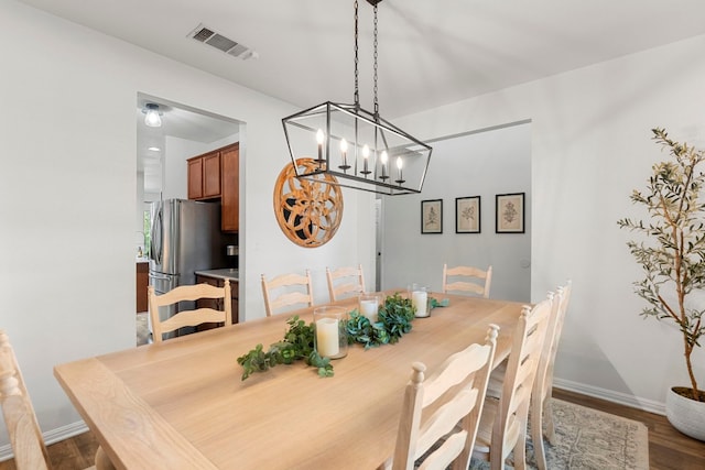 7709 Little Deer Trl, Georgetown, TX 78628 - dining area featuring baseboards, visible vents, wood finished floors, and a notable chandelier