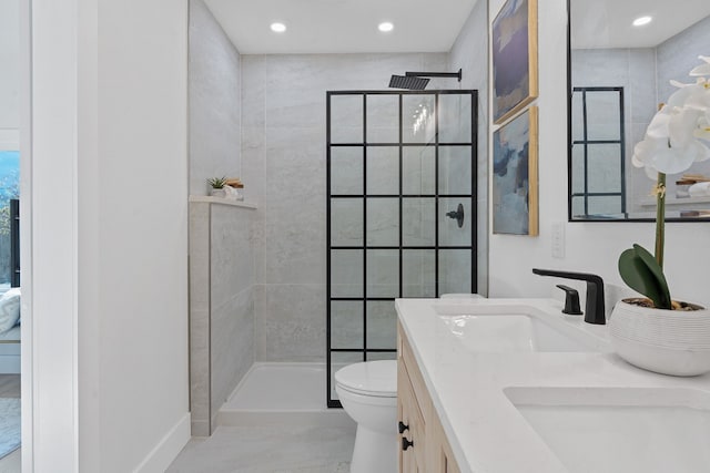 bathroom featuring vanity, toilet, and tiled shower