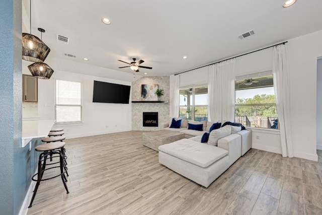 living room featuring a healthy amount of sunlight, ceiling fan, and light hardwood / wood-style flooring