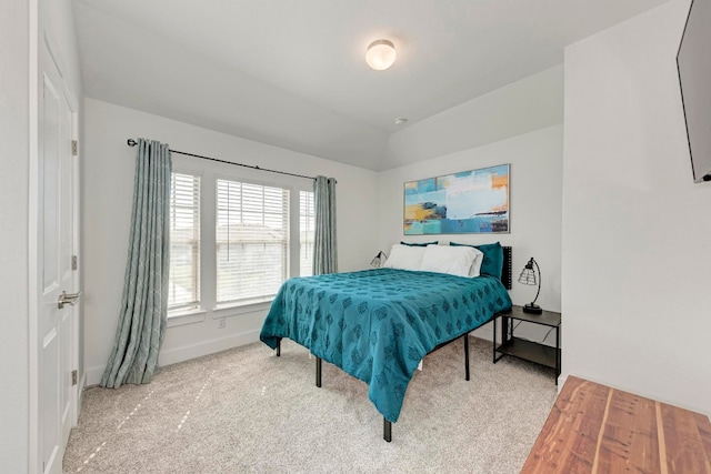 carpeted bedroom with lofted ceiling