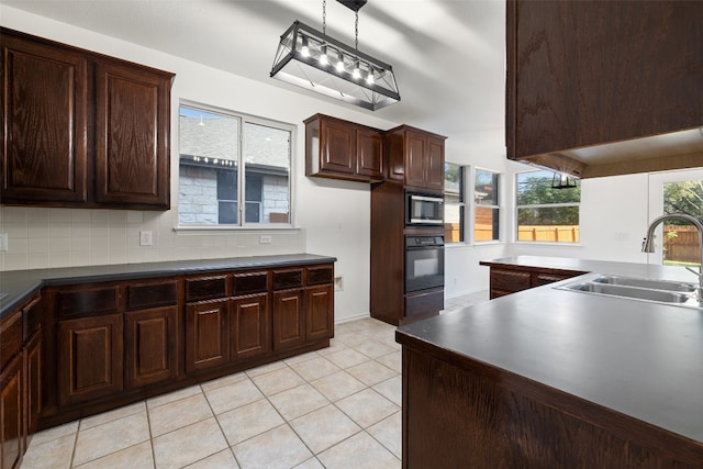 kitchen with pendant lighting, sink, backsplash, oven, and built in microwave