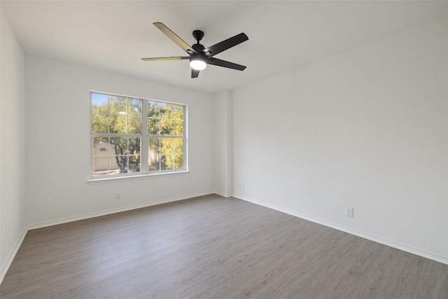 unfurnished room with ceiling fan and dark hardwood / wood-style flooring